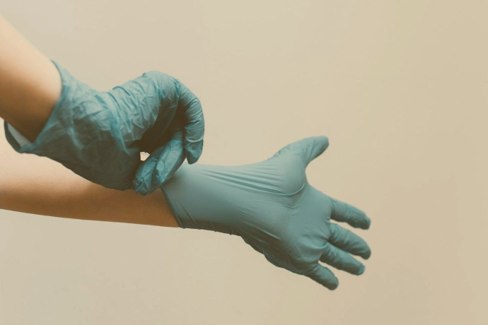 Zu sehen sind Hände in medizinischen Einweghandschuhen. 