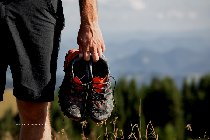 Einlagen für den Sport Zu sehen ist ein Mann in Sportbekleidung mit Sportschuhen in der Hand.